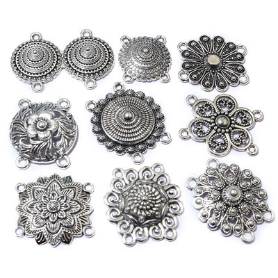 Overview of an assortment of ornate floral and circular connectors with multiple hanging loops in silver tone