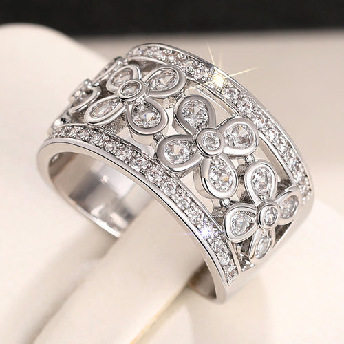 Product view showing silver-tone five-petal floral openwork extra-wide ring