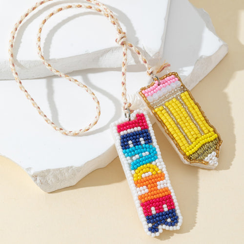 Close-up of the yellow beaded pencil charm and colorful TEACHER text charm