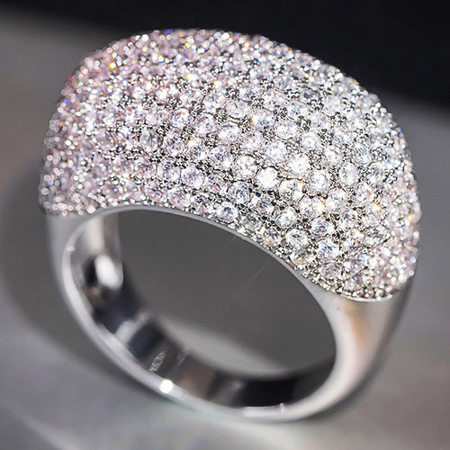 Studio angle of white gold pave dome ring on gray surface