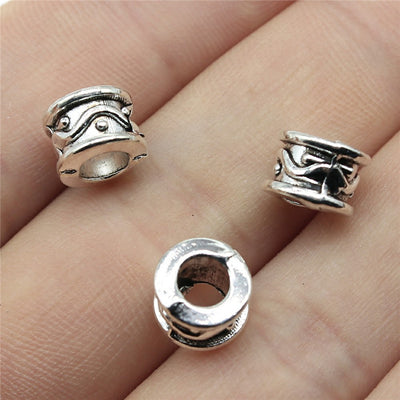 Antique Gold, Antique Silver, Antique Bronze wavy barrel large-hole bead front view on fingertips