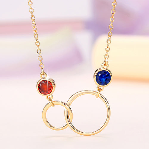 Angled detail of interlocking circle necklace with red and blue crystals