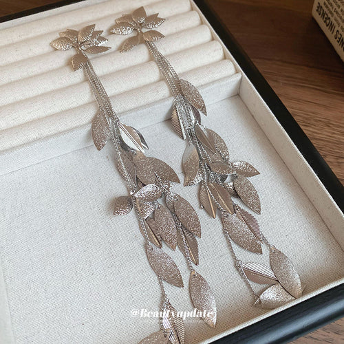silver tone layered leaf vine long drop stud earrings displayed from a second angle
