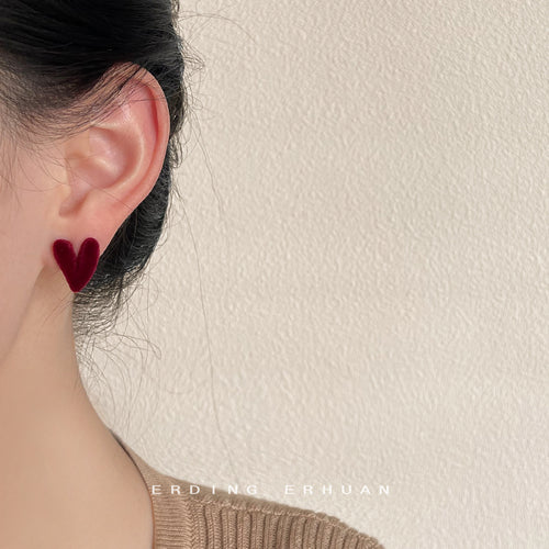 Wine red flocked heart stud earring worn on ear side profile