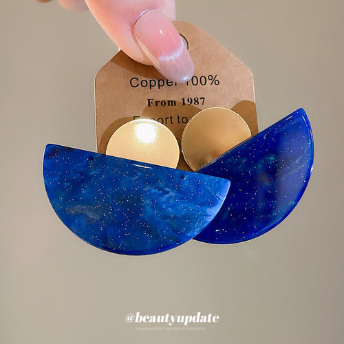 Styled wear view of 蓝色半圆耳钉 showing mottled deep blue semicircles paired with brushed gold-tone round tops