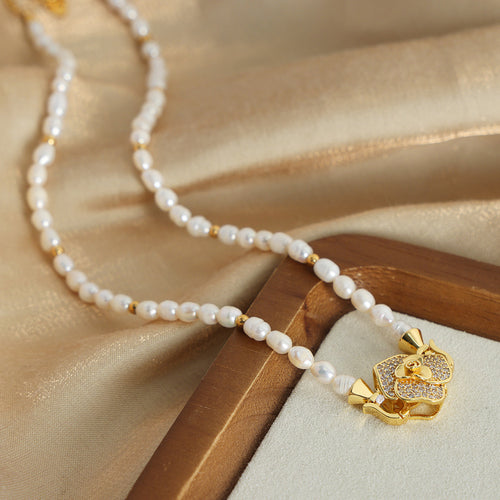 White pearl necklace gold flower clasp on silk tray