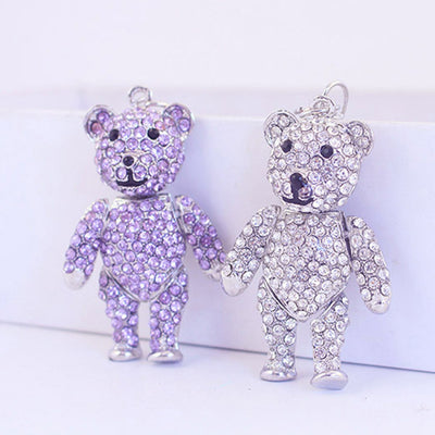 Purple and clear stone-covered bear charms stand side by side.
