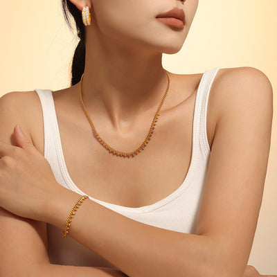 Model wearing gold bead rhinestone curb necklace and bracelet
