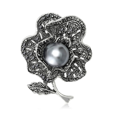 The first image shows the black flower and pearl brooch from the front.