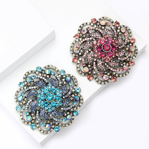 Pink and blue large flower brooches on white display blocks