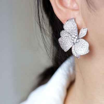 Silver pave clear CZ flower orchid stud worn on ear lobe