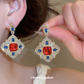 Red Center Ornate Crystal Drop Earrings with Polished Metal Tone Details view 1