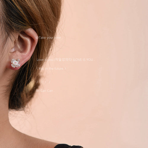 Side profile wearing pearlescent flower stud earring