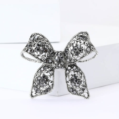 Antique silver black crystal bow brooch front on white blocks