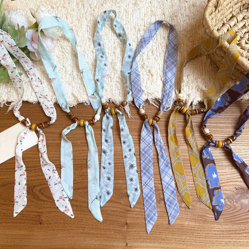 Styled view of patterned scarf necklaces with smooth starfish pendants
