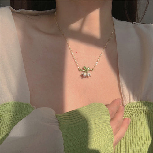 Green Vine Pearl Floral Bracelet Necklace and Earring selection shown in ear-worn front view