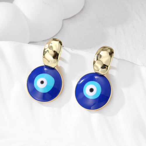Close-up showing the colors and surface details of gold Tone Hammered Stud Blue Evil Eye Drop Earrings