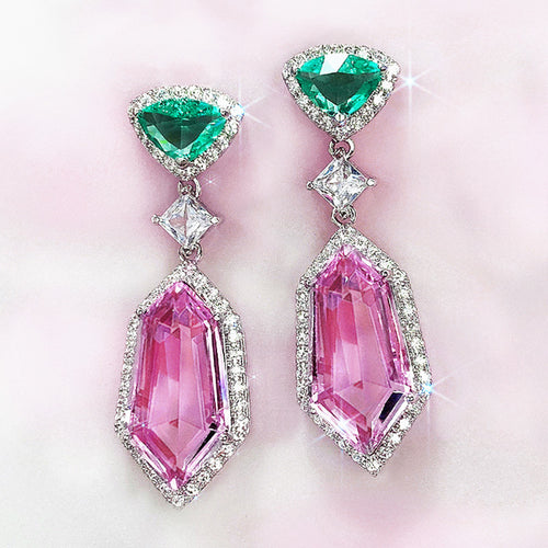 Pink kite drop earrings with green triangle tops on pink backdrop