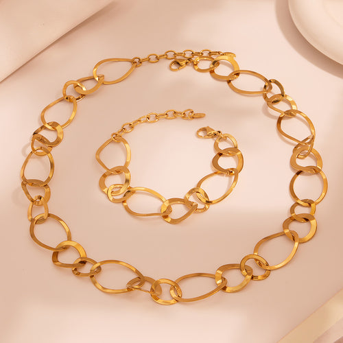Flat lay gold irregular oval circle necklace and bracelet on beige surface