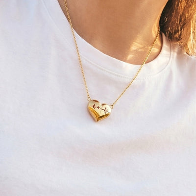 Gold heart ECG pendant necklace worn on white tee