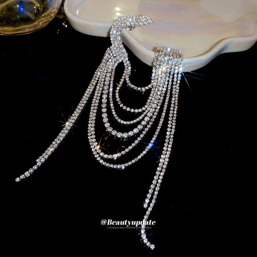 Silver crystal geometric tassel brooch close up on black surface