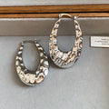 Textured Open Oval Huggie Earrings with Polished Metal Tone Details view 6