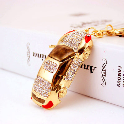 Angled top view of the rhinestone car charm beside a white book.