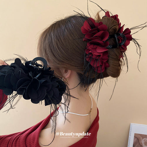fabric petal flower hair claw with black feather fringe in red or black shown in the first close product view
