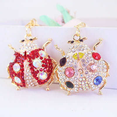 Close-up of red and white rhinestone ladybug charms displayed side by side.