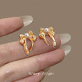 Gold Ribbon Bow Stud Earrings White Pearl Center Pair view 1