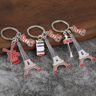 Four Paris keychains with Eiffel Tower and assorted accent charms on gray fabric.