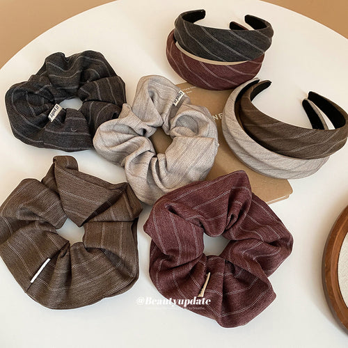 Four herringbone scrunchies and stacked striped headbands on white table
