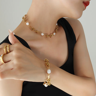 Model in black tank wearing gold knot pearl choker necklace and bracelet