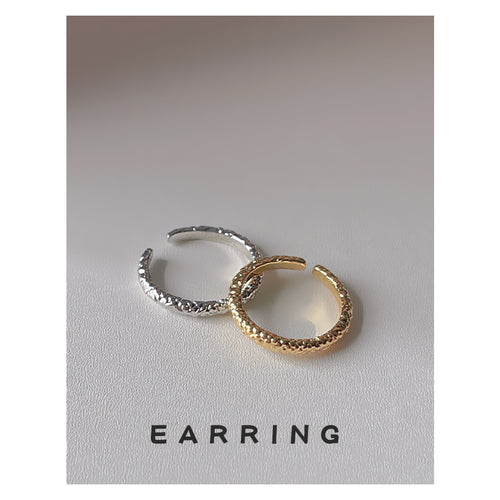 Gold and silver hammered open rings on white surface