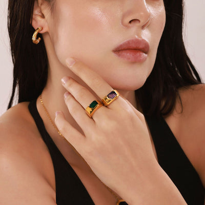 Model wearing gold green and purple zircon open signet rings