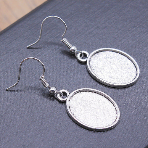 Styled view of plain oval bezel drop earrings in four size-finish options