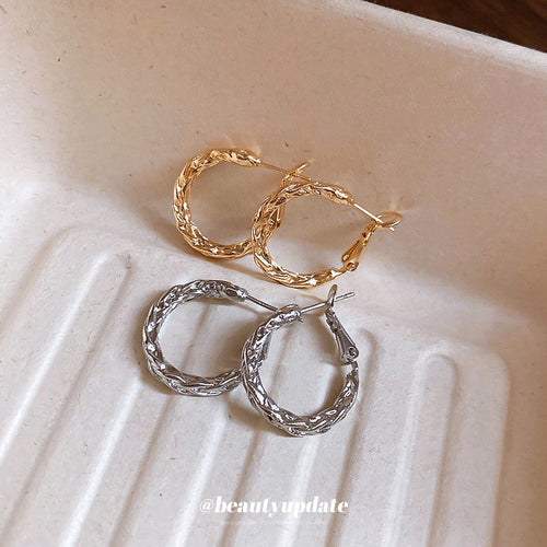Styled close-up of twisted small hoop earrings