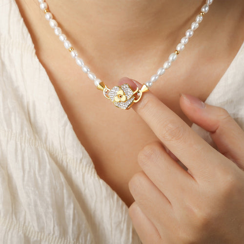 Pearl strand with gold flower pavé clasp worn and held