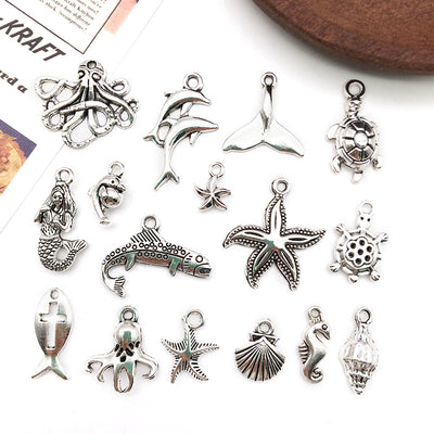 Metallic seahorse and starfish charms arranged on a light background