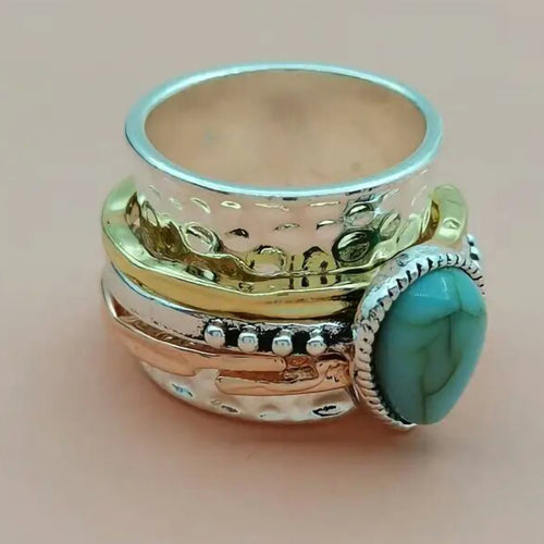 Tri-tone turquoise drop ring side angle showing stacked metal bands