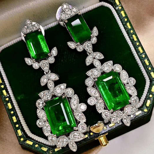 Close pair of green double-stone leaf crystal drops in open case