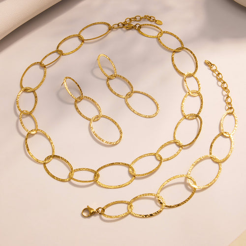 Gold hammered oval necklace bracelet and earrings flat lay