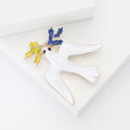 Flying Dove Brooch in Metal with White Enamel Bird Carrying a Small Flower Sprig view 4