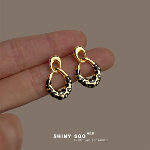 Gold black leopard enamel linked drops held on fingers