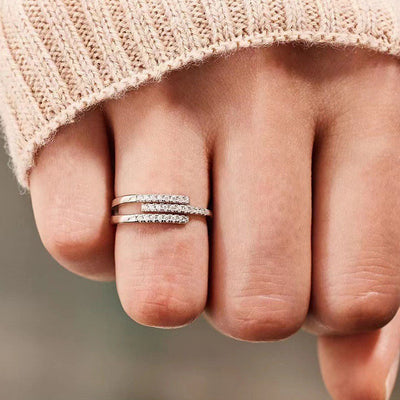 Silver open geometric bar pave ring worn on finger with beige sweater