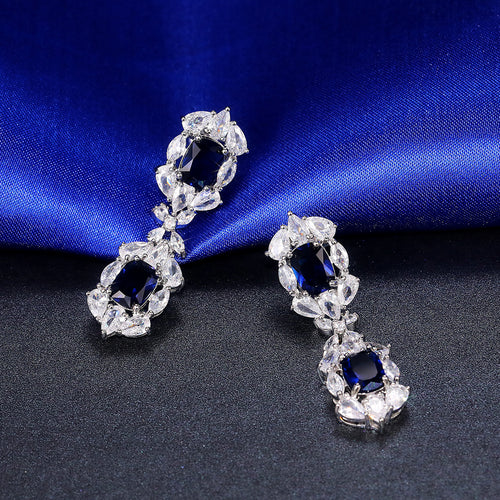 Royal blue long drop earrings on blue satin fabric