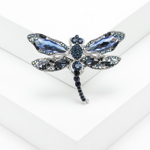 Blue rhinestone dragonfly brooch close-up on white display block