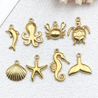 Metallic shell and seahorse charms arranged on a light background