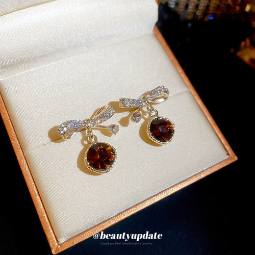 Close view of the colors and surface details on brown round drop bow stud earrings