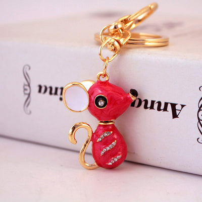 Close-up of a red mouse charm attached to a gold-tone key ring and clasp.